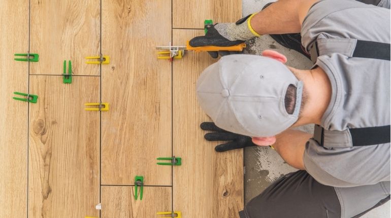 Equipe aplicando porcelanato com alinhamento e nivelamento